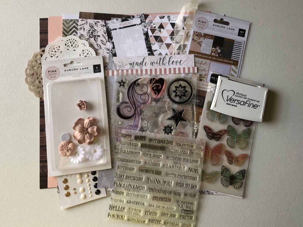 Mini scrapbook kit with patterned paper, cardstock, stickers, butterflies, doilies, enamel dots, flowers & stamps